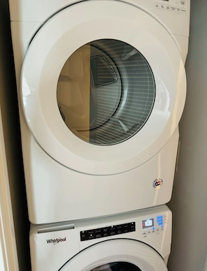 Modern laundry area with a Whirlpool washing machine and control panel.