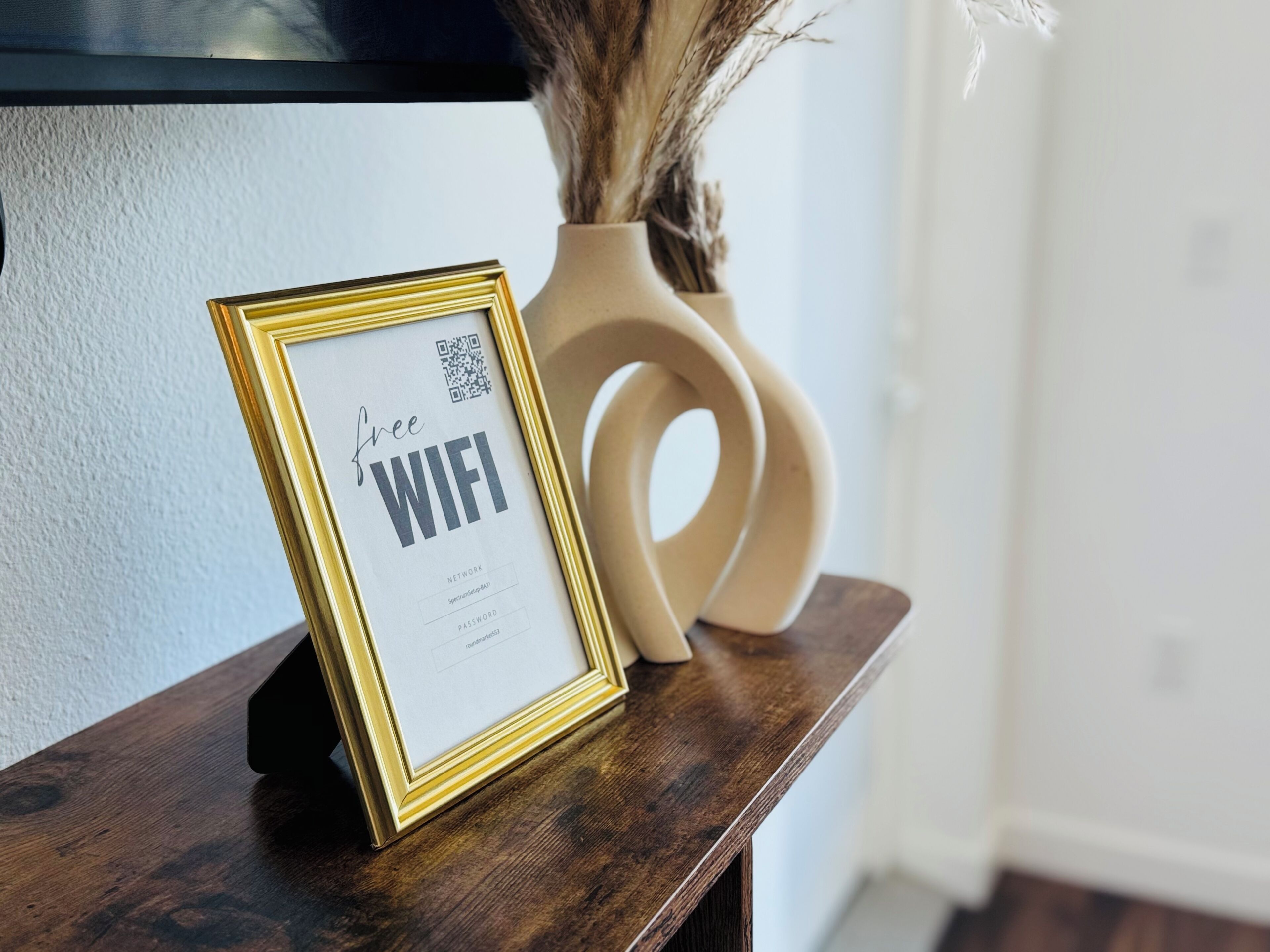A framed sign with "free WIFI" on a wooden surface.