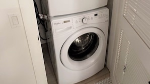A stacked washer and dryer unit in a laundry room. - Cozy Walk of Fame gem. 1b1b, Free Parking, Pool, Private Balcony, WiFi & more! (Los Angeles)