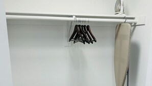 A closet with a white iron, a hanging rack with clothes, and a storage bag labeled "INTEX" on the floor. - Cozy Walk of Fame gem. 1b1b, Free Parking, Pool, Private Balcony, WiFi & more! (Los Angeles)