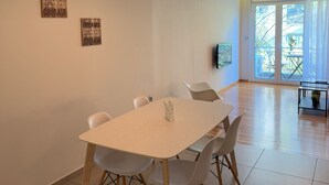 A dining area with a table and chairs, a pendant light, and two motivational posters on the wall.