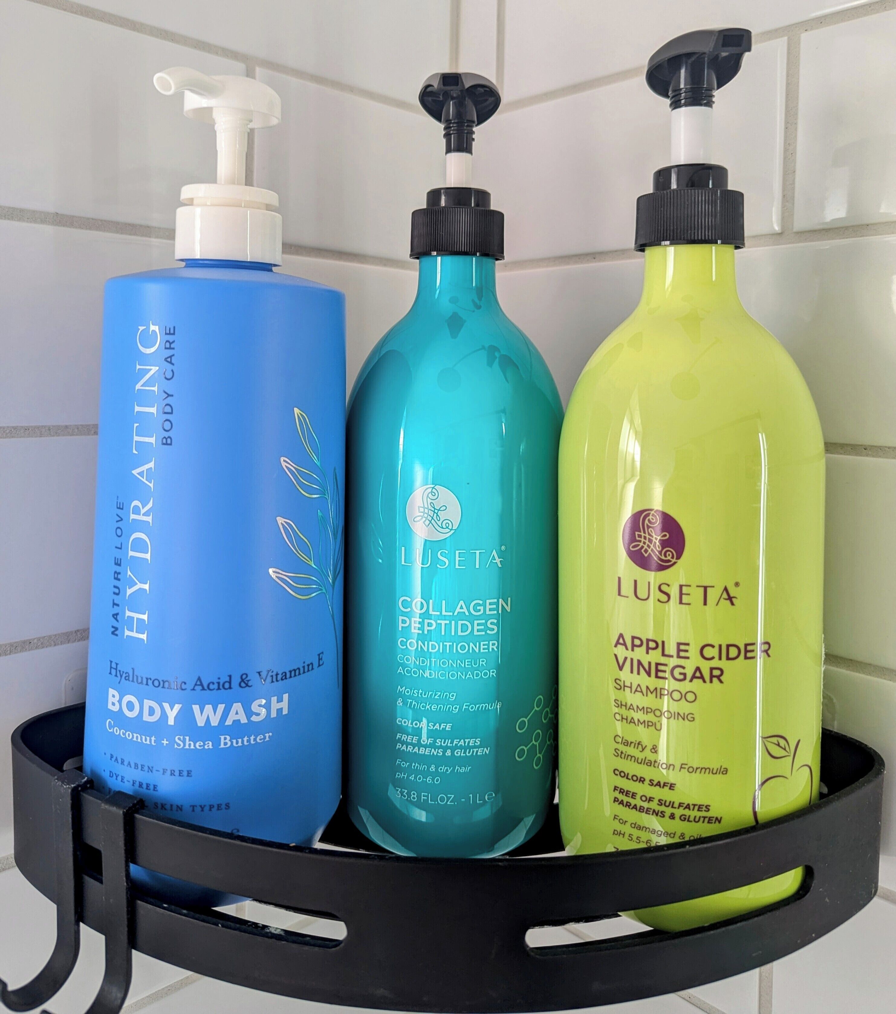 Trois bouteilles de gel douche et d’après-shampoing, présentées dans un présentoir noir.