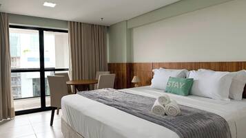 Una habitación de hotel con una cama grande, un escritorio y una silla.