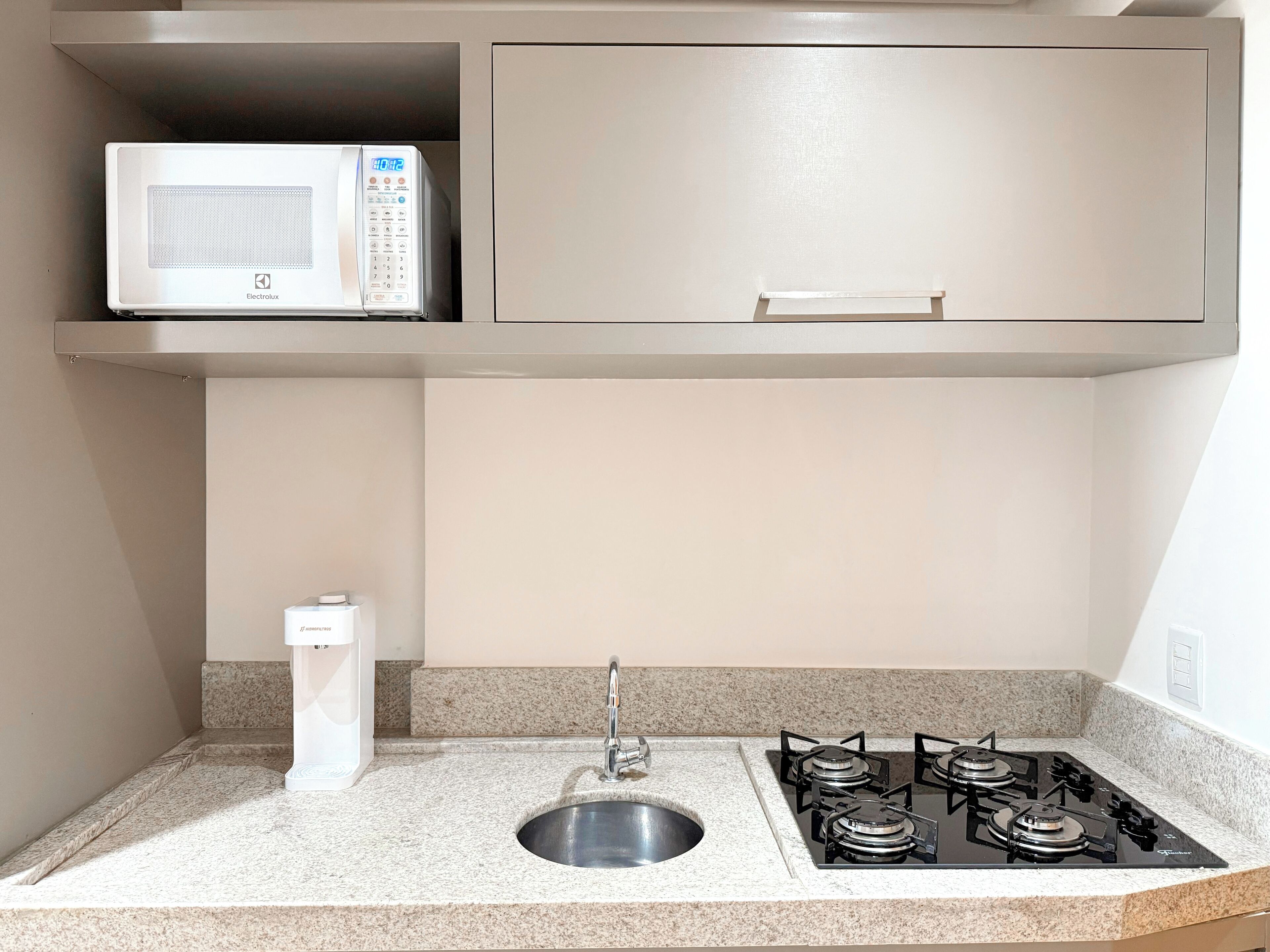 A kitchen with a microwave, a sink, and a gas stove.