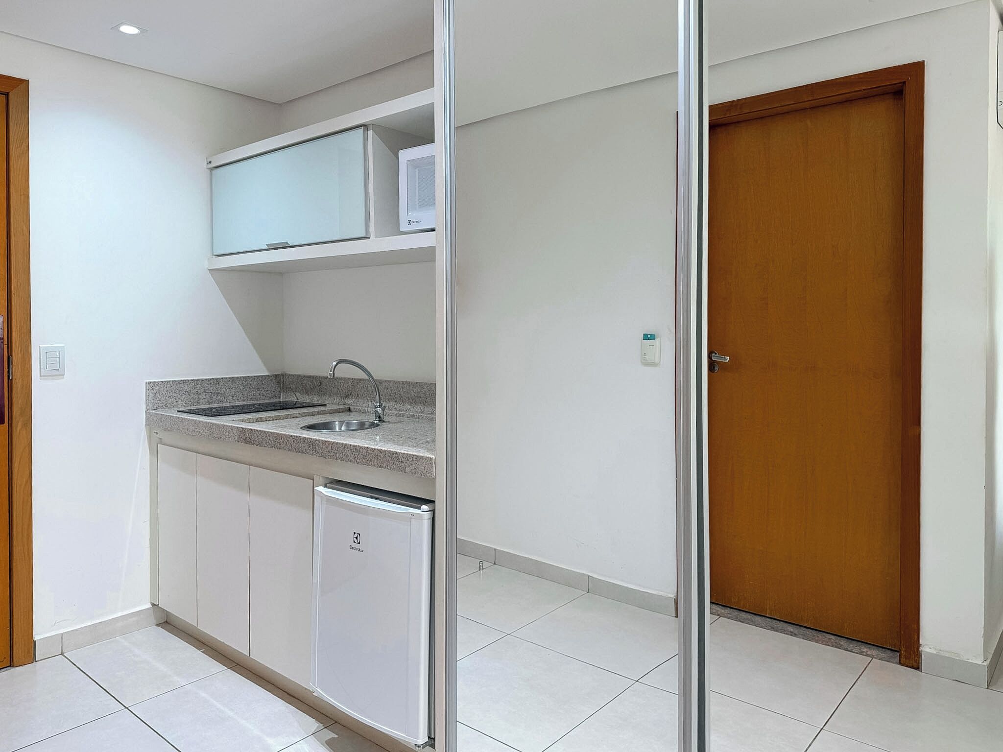 A kitchen with a sink, countertop, and a refrigerator.