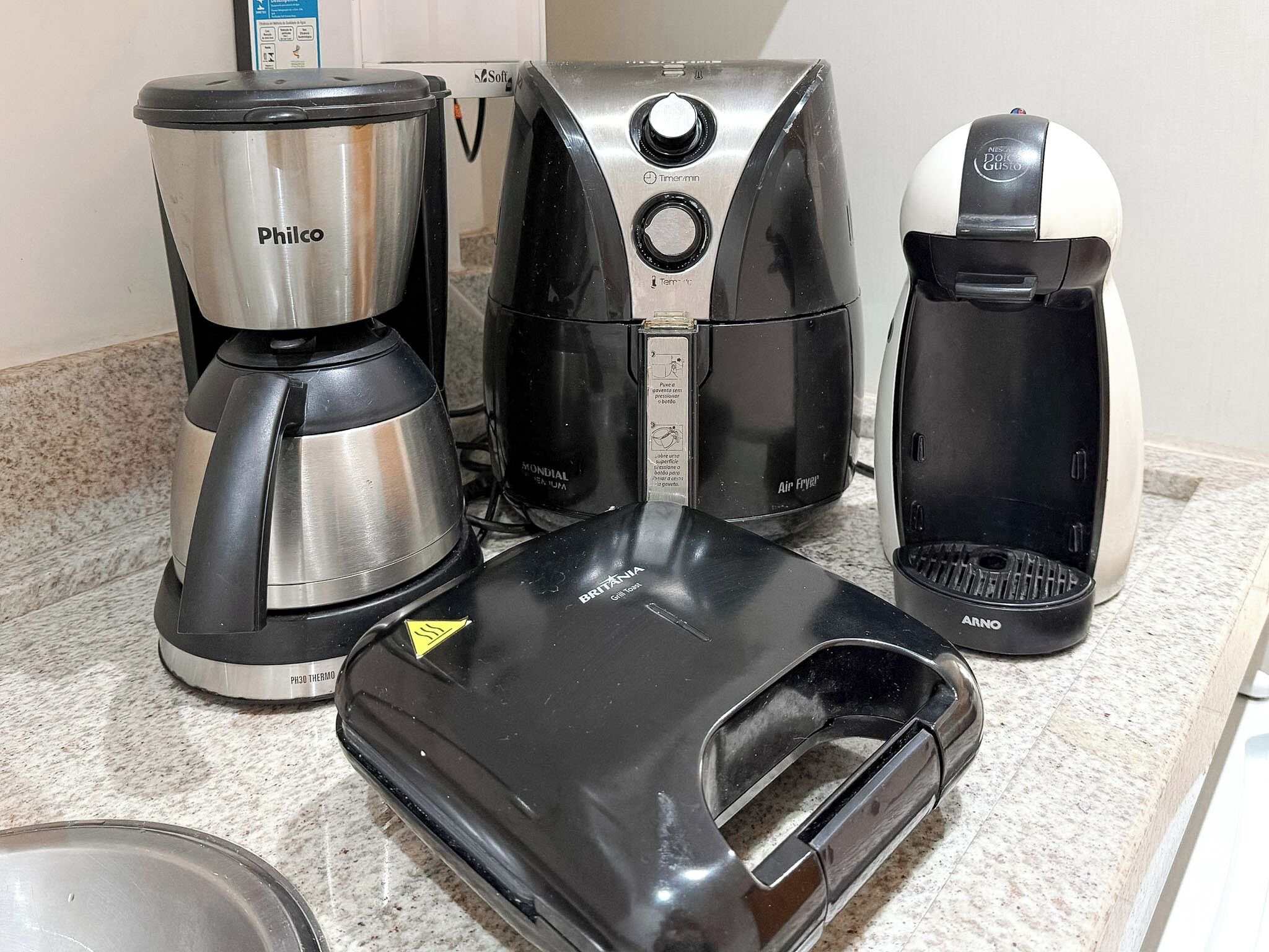 A kitchen counter with a coffee maker, a toaster, and a kettle.
