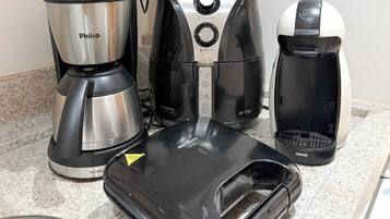 A kitchen counter with a coffee maker, a toaster, and a kettle.