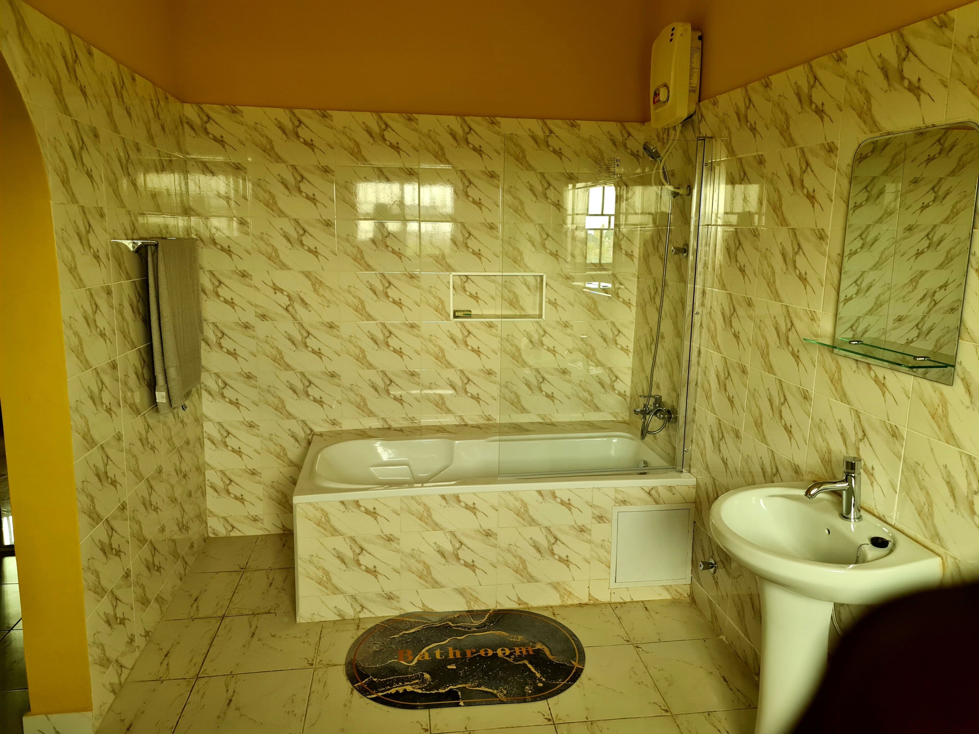 A bathroom with a bathtub, a sink, and a mirror.