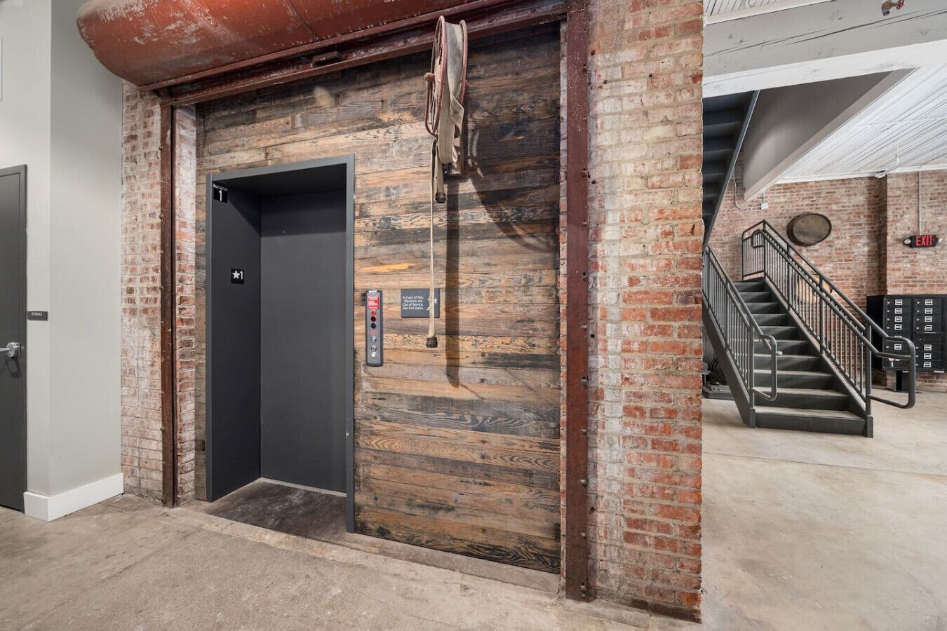 An elevator with a rustic wooden finish and a modern control panel.