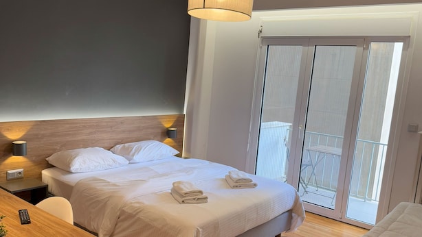 Een moderne slaapkamer met een bed, nachtkastje en bureau.