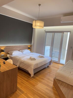 A modern bedroom with a bed, bedside table, and a desk.