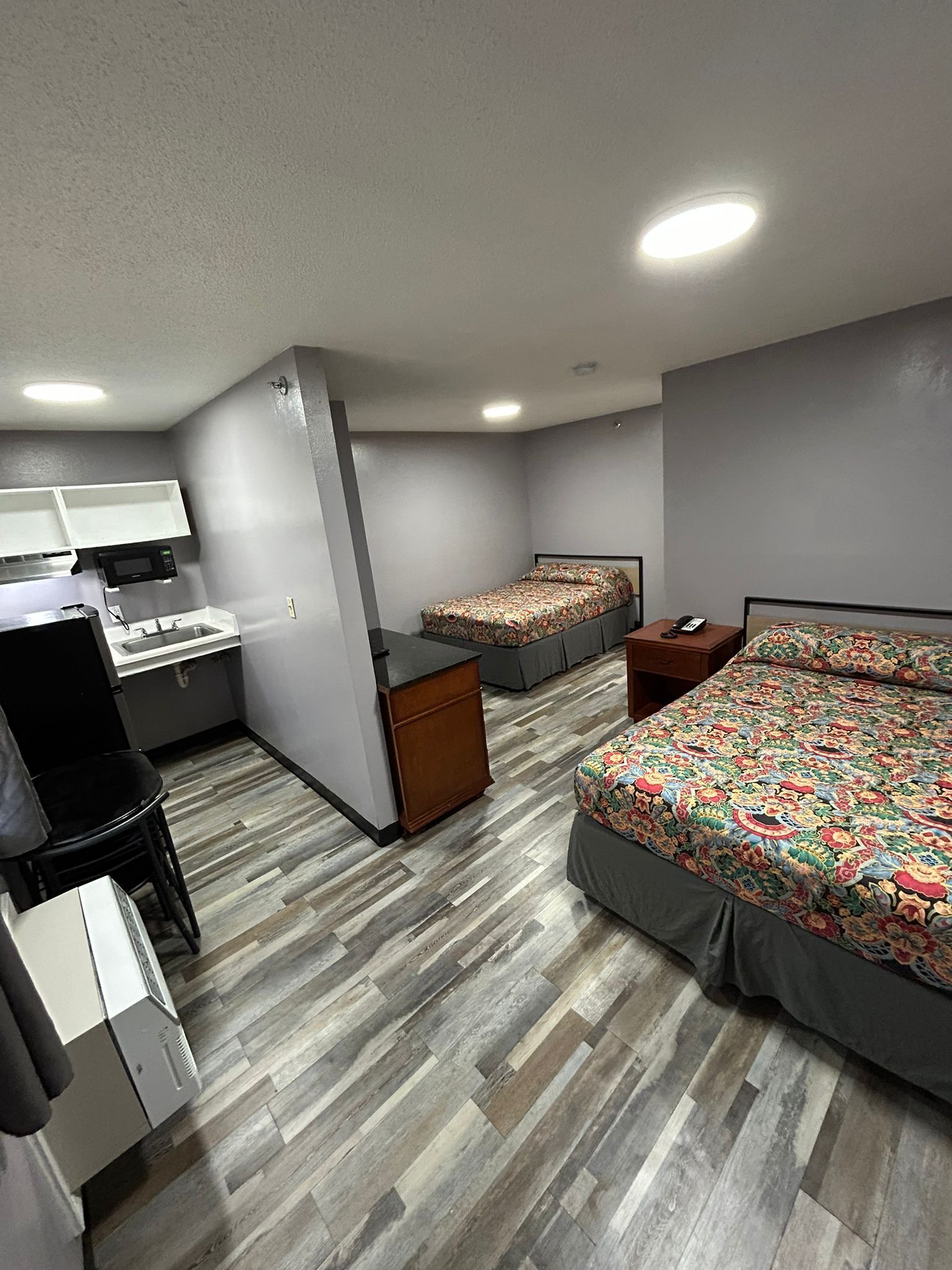 A compact bedroom with a bed, a desk, and a chair.