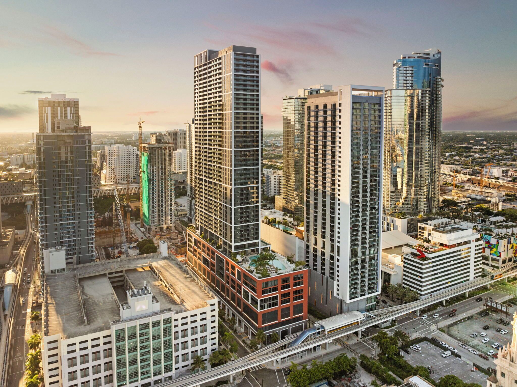 A high-rise building with a modern architectural design, featuring a prominent glass facade and a rooftop garden.