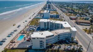 A beachfront hotel with a pool, parking, and a view of the ocean. - Cozy new Daytona Beach studio with pool access,sunset and ocean views. (Daytona Beach)