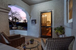 A covered patio with wicker furniture, a glass table, and potted plants. - Total of 2 BR 2 BA / Your Own Duplex / Near U of A (Tucson)