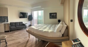 Relax in a stylish room with a large bed, sofa, and flat-screen TV, offering a view of a nearby clock tower.
