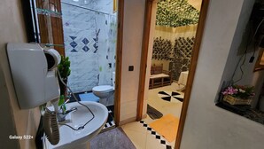 A bathroom with a white sink, toilet, and glass shower enclosure.