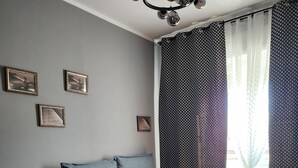 A bedroom with a bed, a chair, and a chandelier.