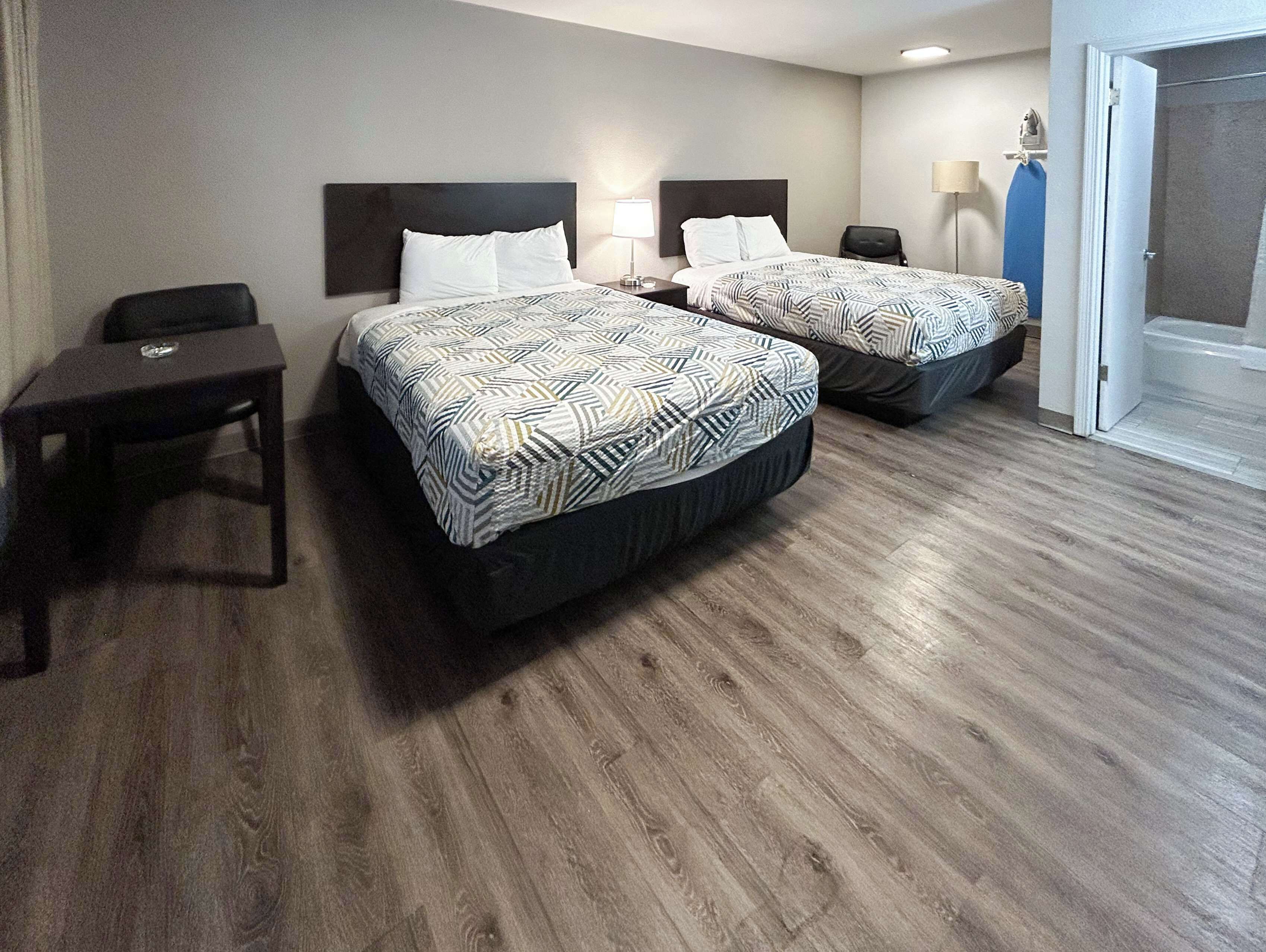 Ein Hotelzimmer mit zwei Betten, einem kleinen Tisch und einem Stuhl.