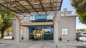 A modern building entrance with a 'welcome' sign, a covered entrance area, and a satellite dish. - Studio 6 King Of Prussia, Pa - Philadelphia (Wayne)