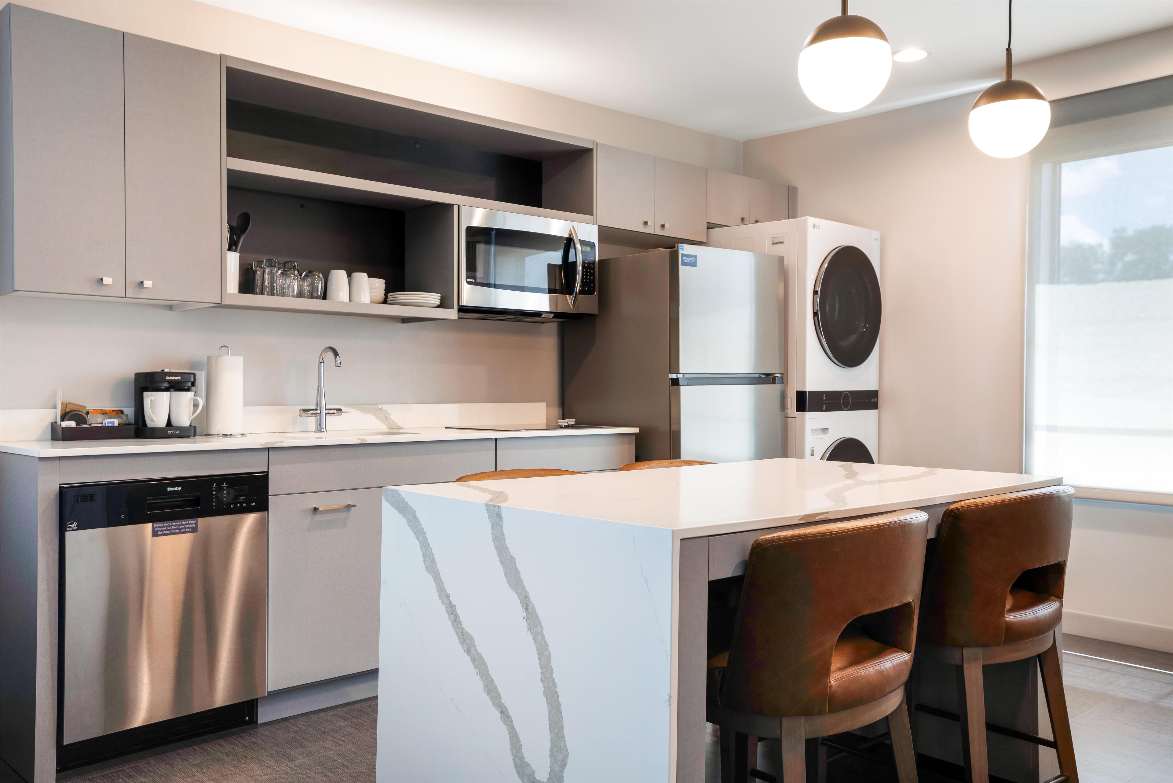 A modern kitchen with stainless steel appliances, a dishwasher, and a built-in oven.
