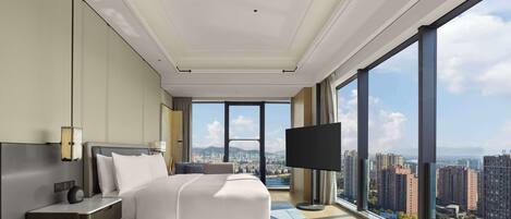 Una habitación de hotel moderna con una cama grande, televisión y vistas a la ciudad.