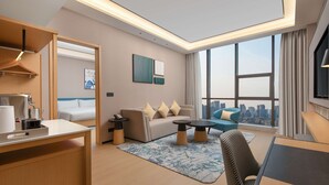 Une chambre d’hôtel moderne avec vue sur la ville, comprenant un canapé, un coin repas et un bureau.
