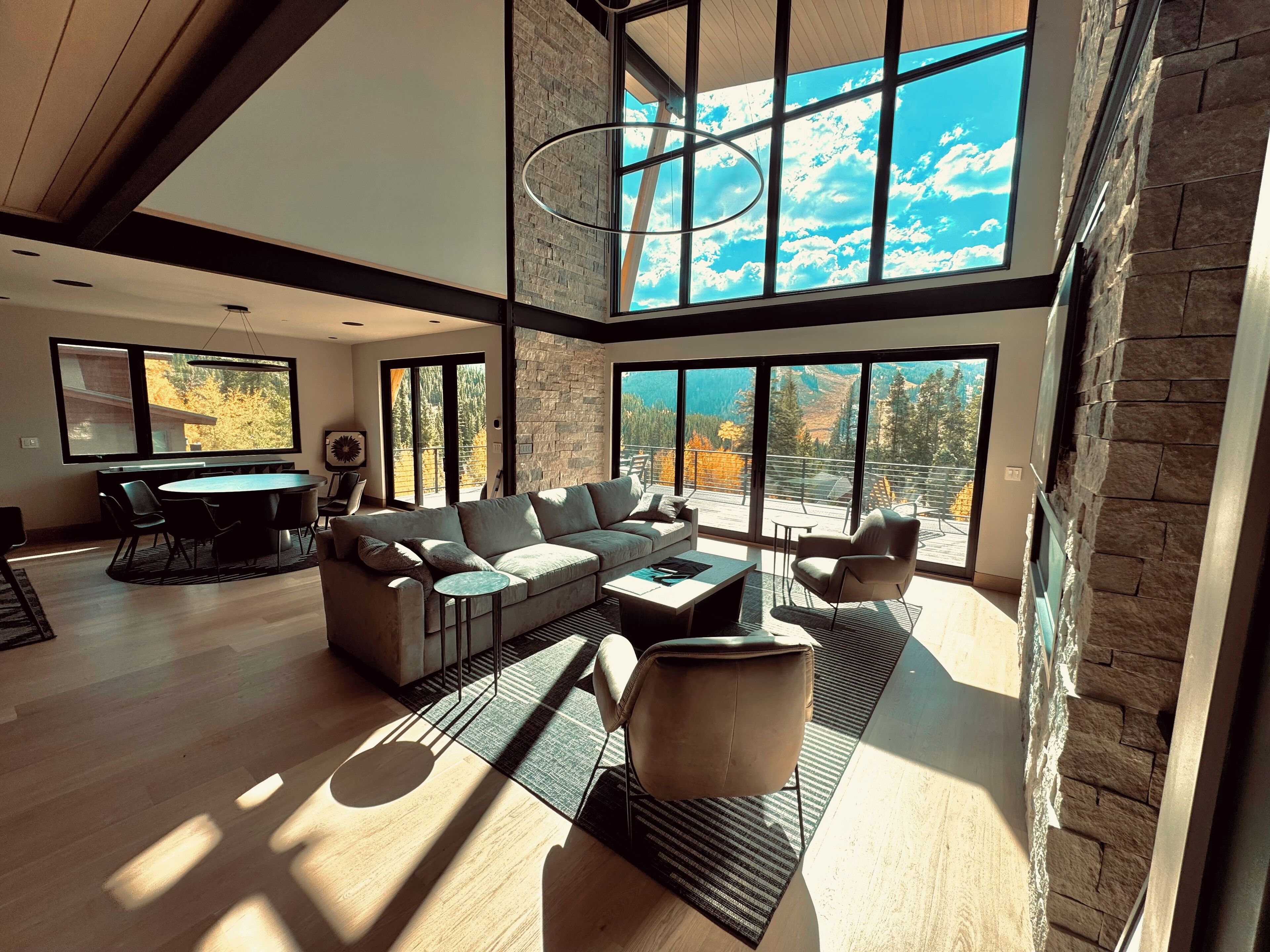 A spacious living room with a large sofa, a coffee table, and a dining area with chairs.
