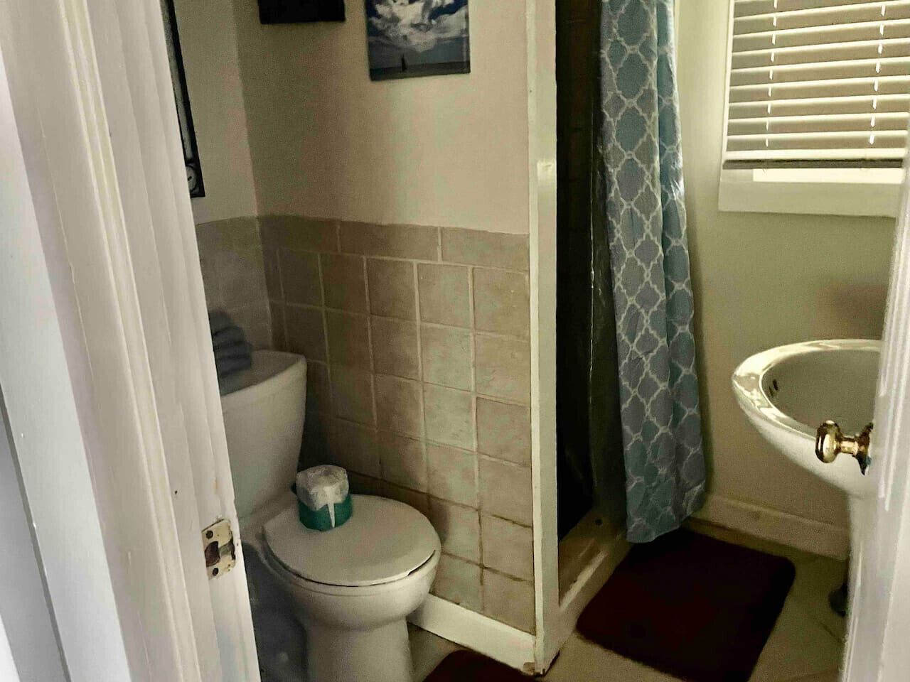 A small bathroom with a toilet, a sink, and a shower curtain.
