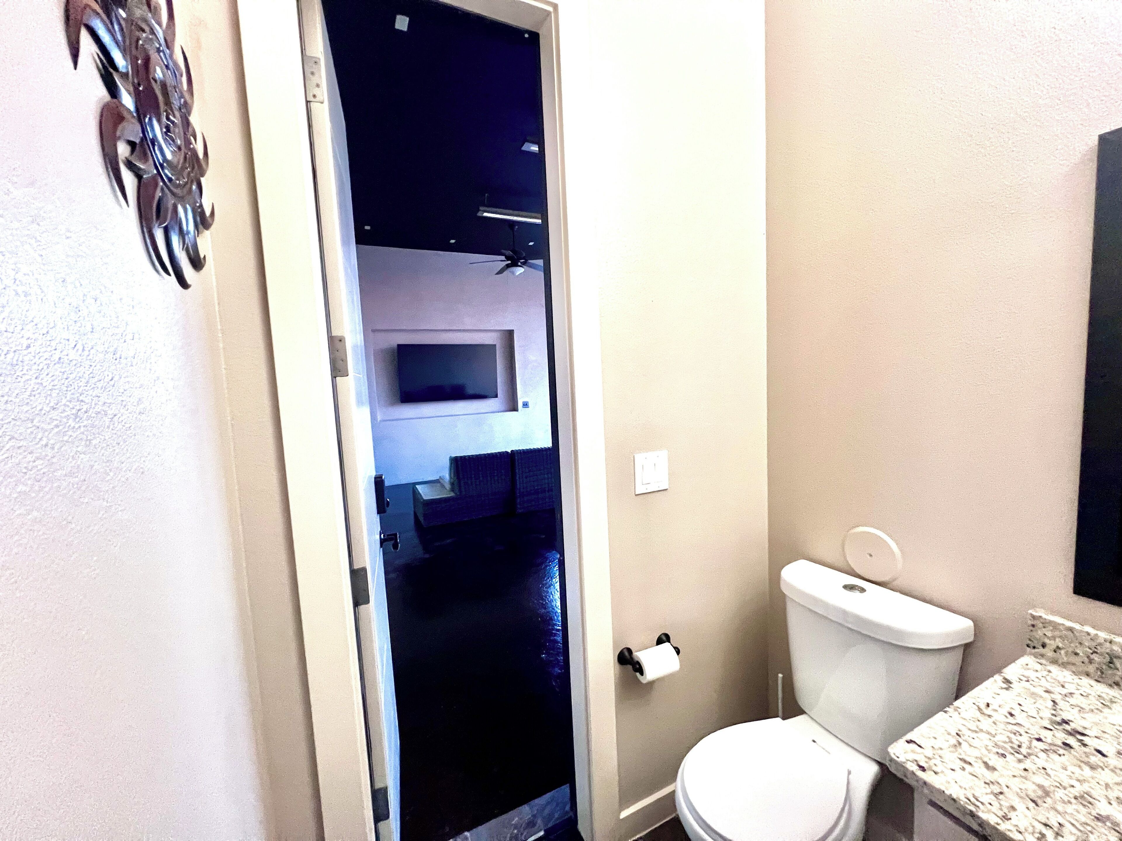 Une salle de bain avec des toilettes, un lavabo et un miroir.