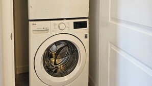 Una lavadora y secadora apiladas en un cuarto de lavandería.
