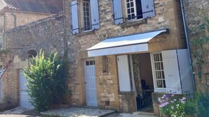 A stone building with multiple windows and a covered entrance. - Charming house with panoramic terrace in Domme - Sarlat (Domme)