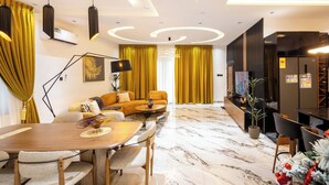 A modern living room with a wooden dining table, yellow curtains, and a sofa with a decorative vase. - Reoky Pads - Redefining comfort and luxury. (Accra)