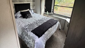 Ein Schlafzimmer mit Bett, Fenster und Tür.