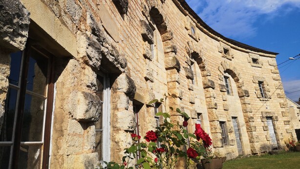 A stone building with arched windows and a curved facade. - 3 Chambres table d'hôtes in the countryside le nid qui danse near Vesoul 8 to 11 pers. (Baignes)