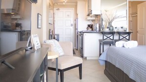 A compact living space with a kitchenette, a dining area, and a bedroom. - 213 Beachfront Heated Pool Gulf View Studio (Galveston)