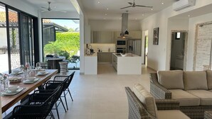 A modern open-plan living space with a dining area, kitchen, and seating area. - Villa Gouverneur, Tamarindo, hacienda Pinilla, Avellanas, Langosta, Costa Rica (Tamarindo)