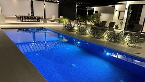 A swimming pool with a tiled edge, surrounded by lounge chairs and small plants. - Villa Gouverneur, Tamarindo, hacienda Pinilla, Avellanas, Langosta, Costa Rica (Tamarindo)