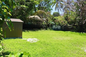 Enjoy a serene outdoor space surrounded by lush greenery and mature trees.