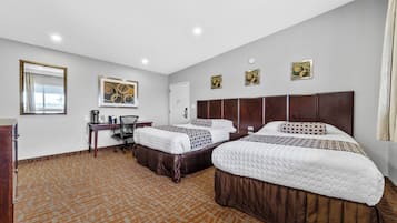 Una habitación de hotel con dos camas, un escritorio y una ventana.