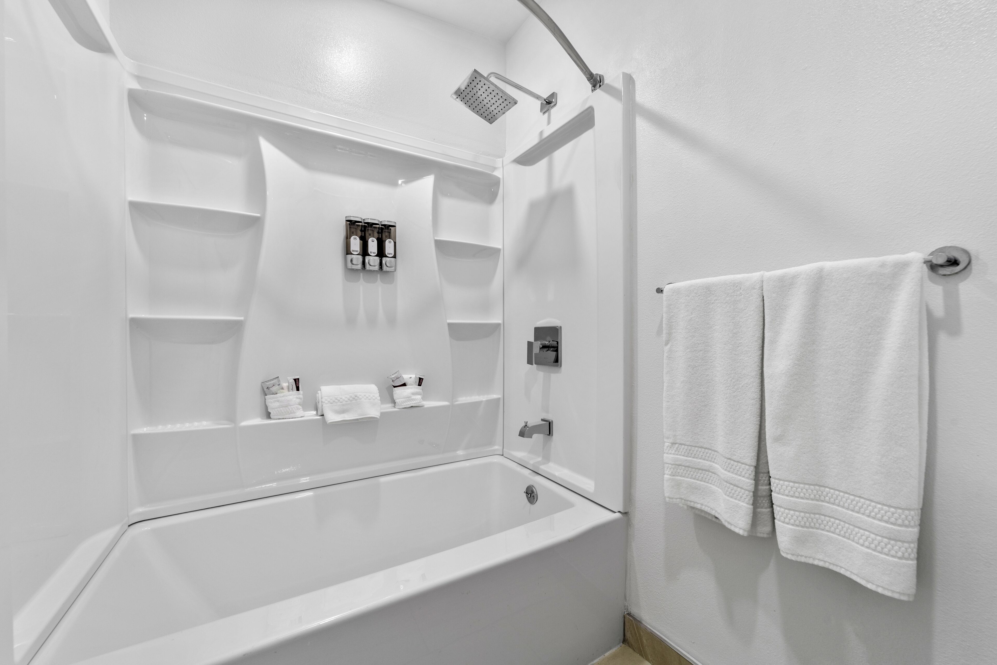 Un baño moderno con bañera, ducha y un perchero para toallas.