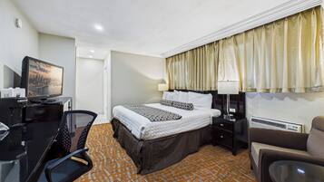 Une chambre d’hôtel équipée d’un lit, d’un bureau, d’une chaise et d’un téléviseur.