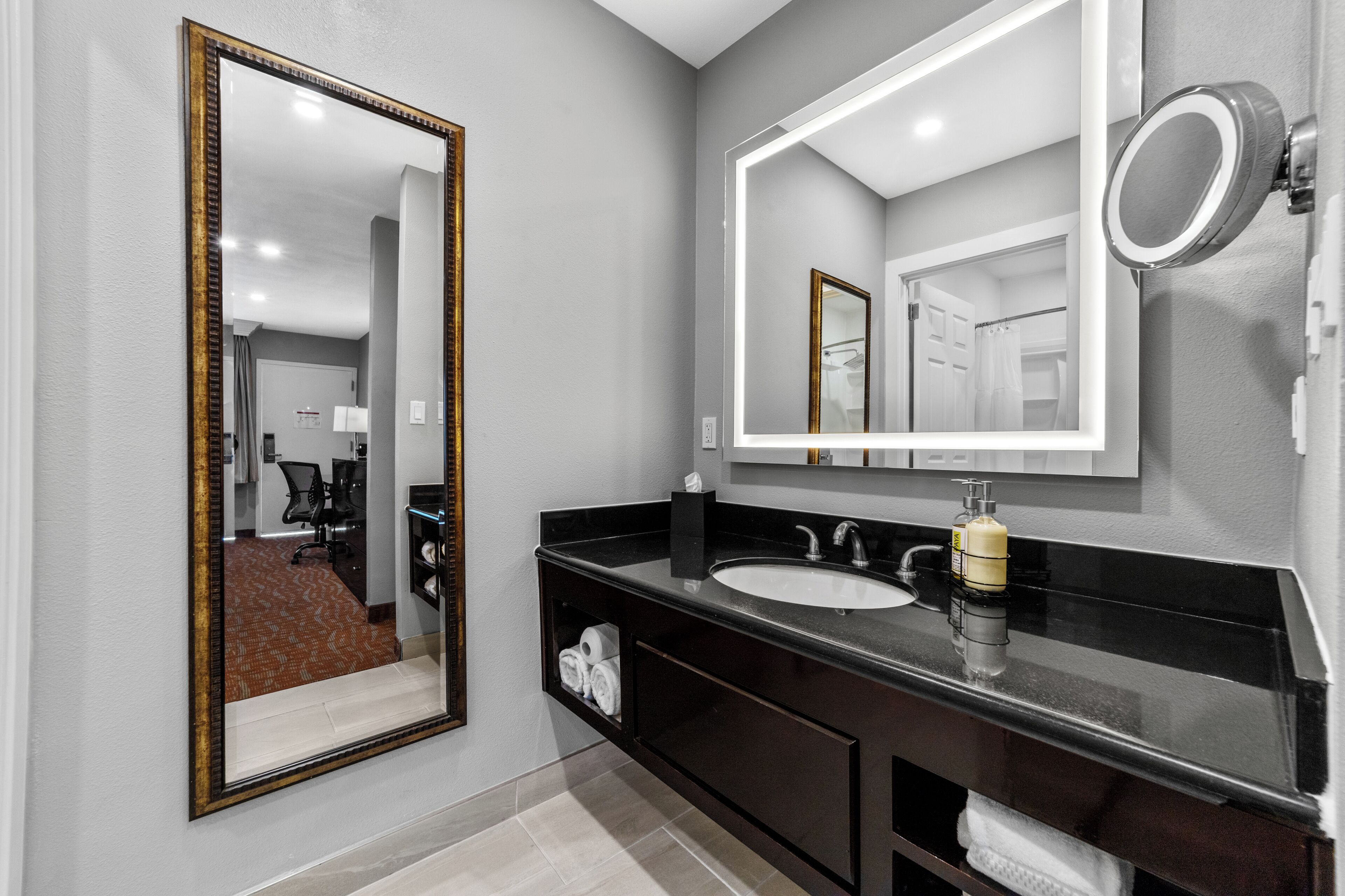 Un baño moderno con un espejo grande, un lavabo y tocador.