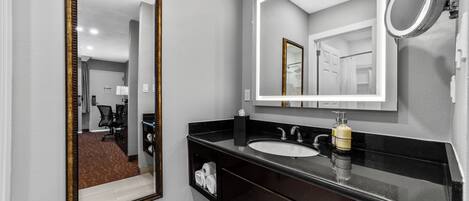 Un baño moderno con un espejo grande, un lavabo y tocador.