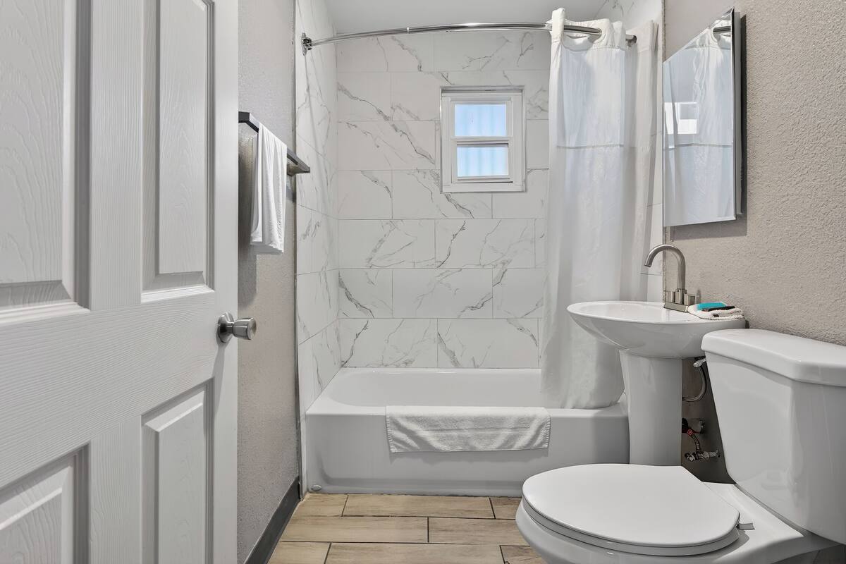 A bathroom with a bathtub, a sink, and a toilet.