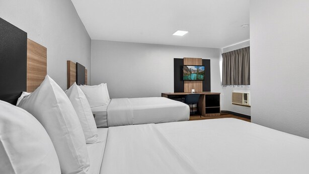 A modern hotel room with a large bed, a desk, and a television. - Rodeway Inn Las Vegas Fremont Street (Las Vegas)