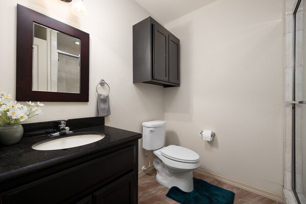 Une salle de bain avec un lavabo, des toilettes et un meuble de rangement.