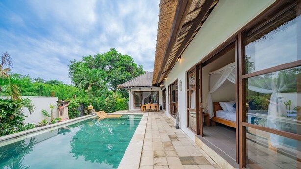 Zona junto a la piscina con vista despejada, comedor con mesa y sillas, y dormitorio con cama y ventanas amplias.