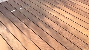 Une terrasse en bois avec une piscine.