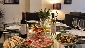 A dining table set with various dishes, wine bottles, and glasses, surrounded by modern furniture and framed artwork on the walls. - Beachfront Escape with Spacious Terrace and Stunning Seaview (Torrevieja)